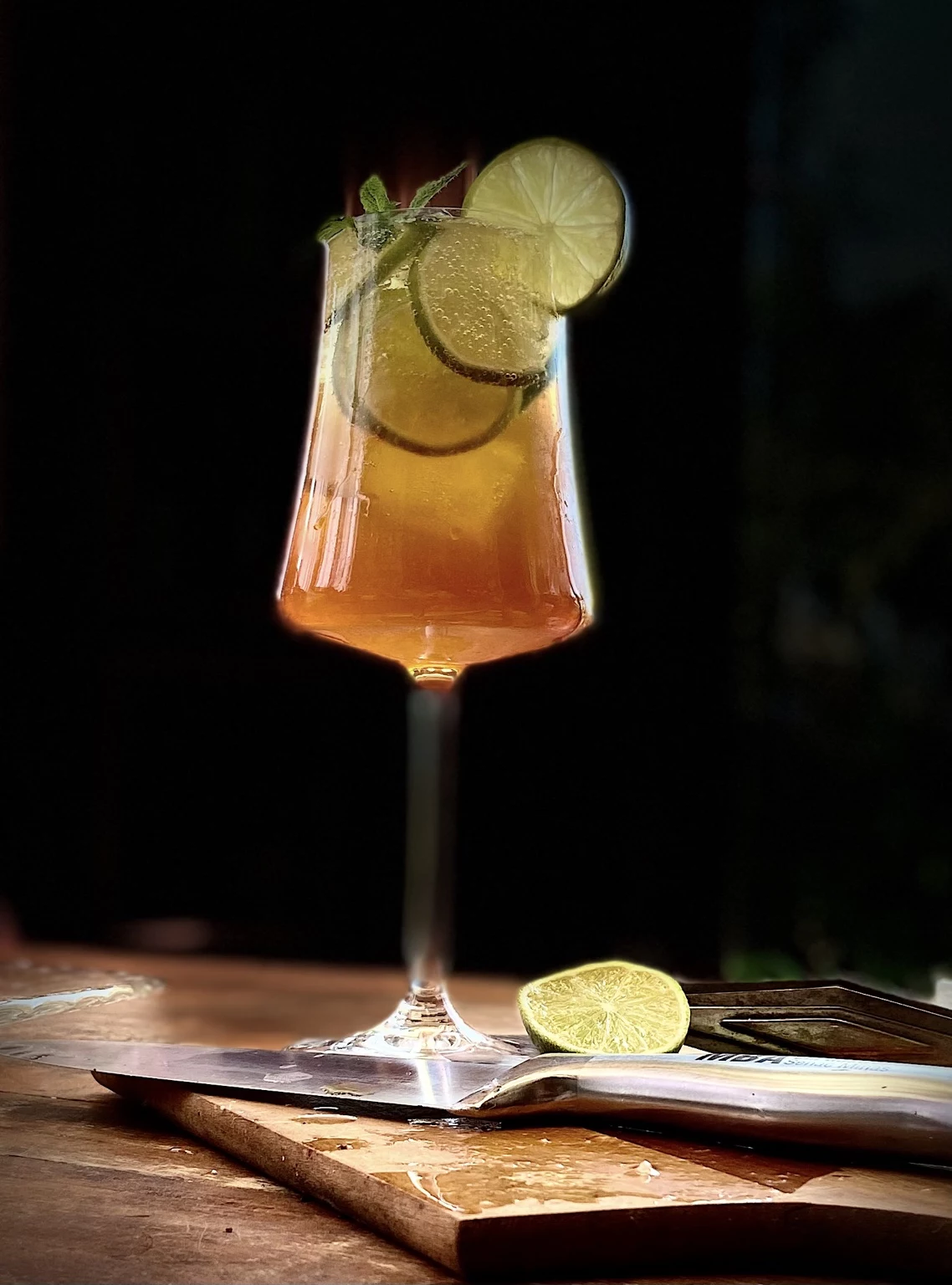 Café tônica com limão e hortelã em taça sobre tábua de madeira